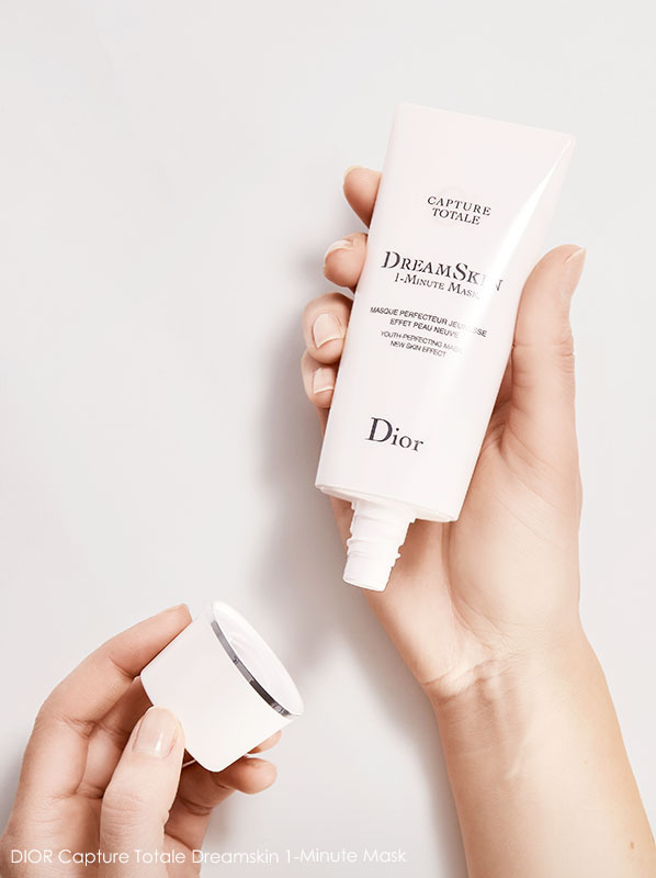 Hands holding an open tube of DIOR Capture Totale Dreamskin 1-Minute Mask