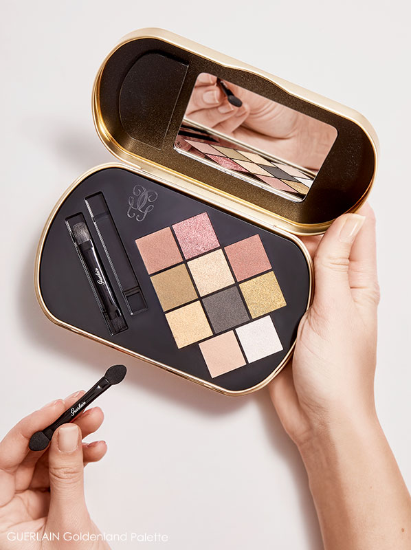 Pair of hands holding an open GUERLAIN Goldenland Christmas Limited Edition Eyeshadow Palette 