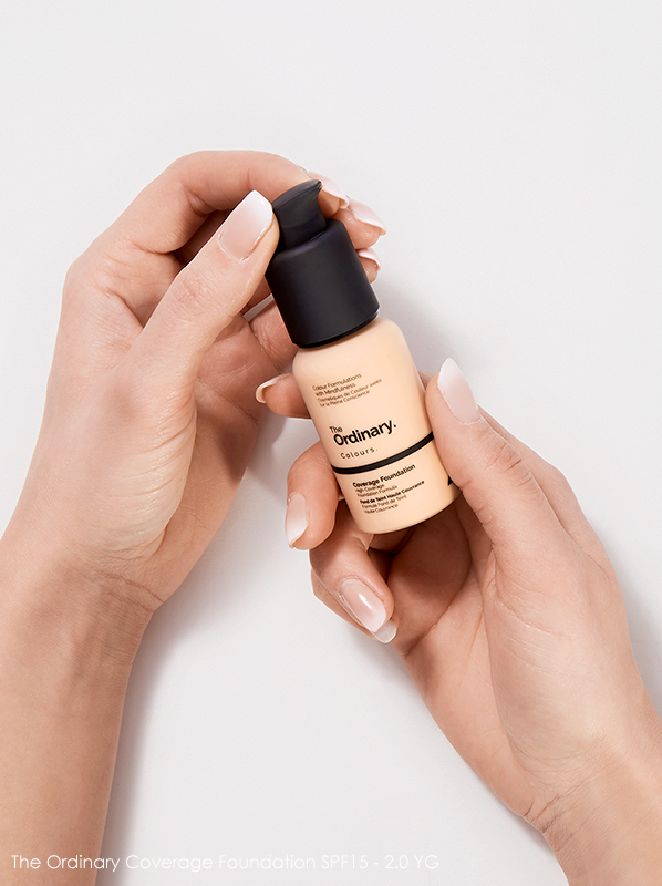 Image of The Ordinary Coverage Foundation SPF15 in 2.0YG being held in hands