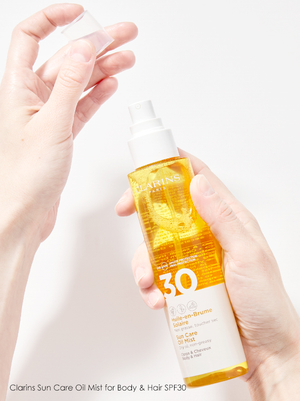 Hand image of Hair SPF Spray Clarins Sun Care Oil Mist for Body & Hair SPF30