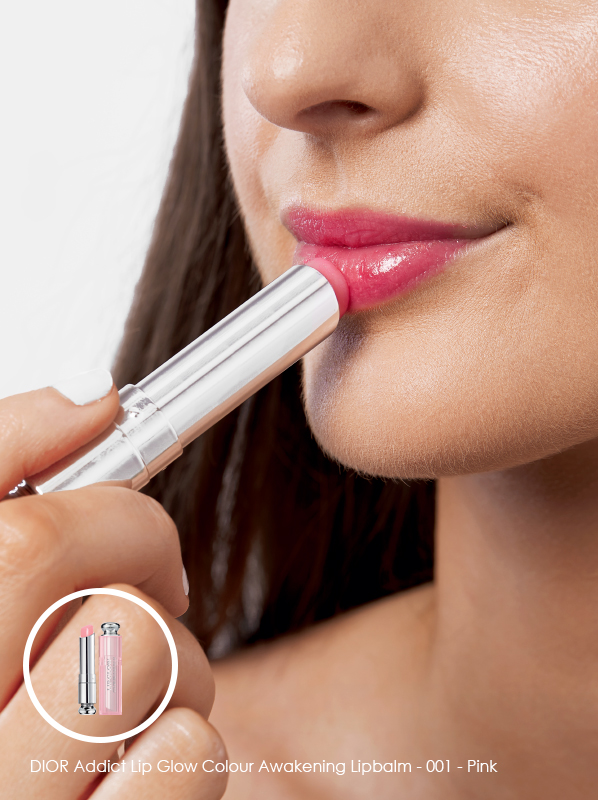 Model swatch shot applying DIOR Addict Lip Glow Colour Awakening Lipbalm in shade 001 - Pink