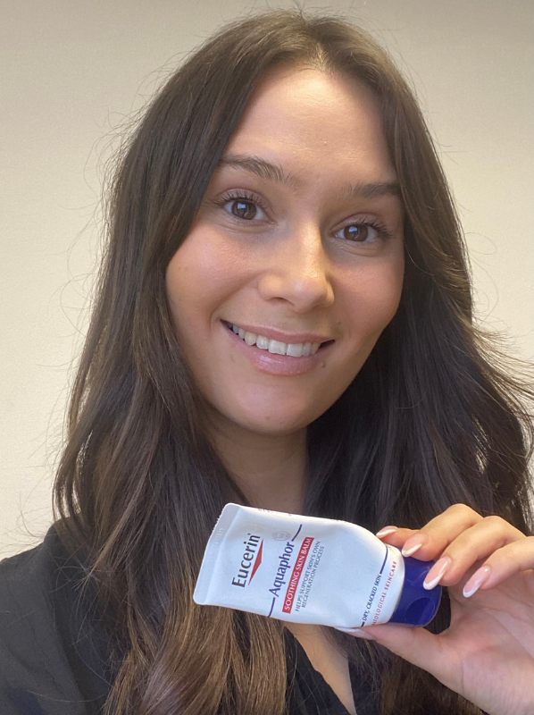 Image model holding Eucerin Aquaphor Soothing Skin Balm for beauty empties 