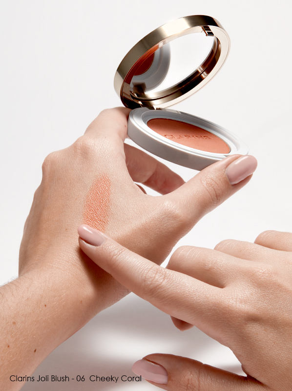 Swatch of Clarins Joli Blush in shade 06 - Cheeky Coral on fair skin on hand
